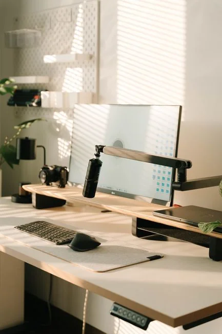 A vibrant workspace featuring a laptop, tablet, and TV with colorful lighting.